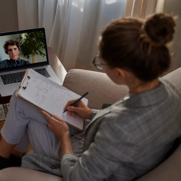 Therapist reviewing notes with a client in a warm consultation room