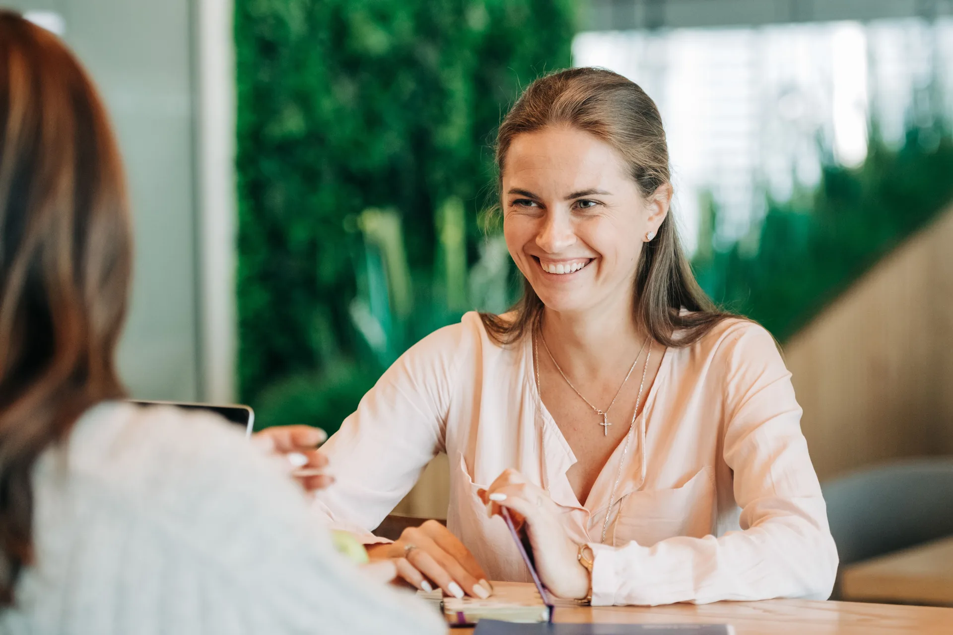 Practitioner speaking with a client at a consultation table